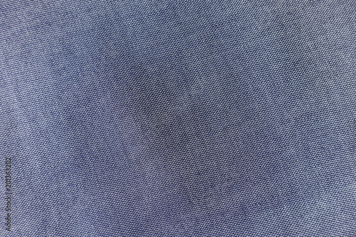 Texture of thin blue jeans fabric from above