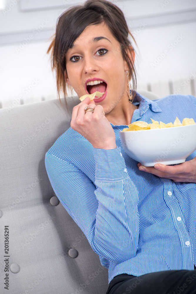 young brunette woman eating chips young brunette woman eating chips