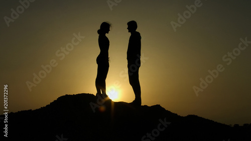 Couple on top of hill against sunset, fateful meeting on edge of earth, love photo