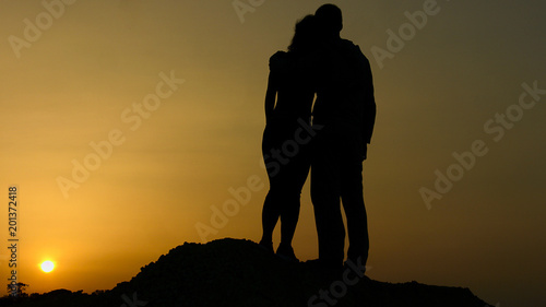 Man hugging woman at romantic date, couple looking at sunset as future with hope