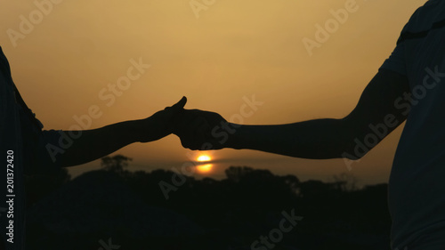 Closeup of man and woman holding hands gently, couple enjoying romantic date