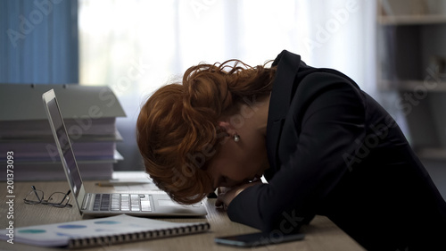 Photos Exhausted woman lying on office desk, working hard on project, deadline pressure