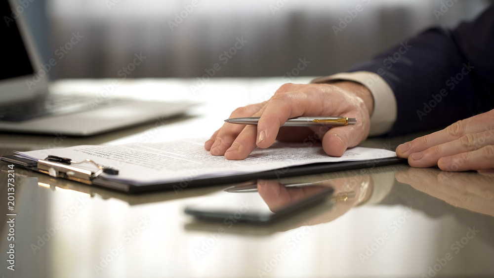 Businessman reading carefully terms, conditions of business contract, close-up Businessman reading carefully terms, conditions of business contract, close-up