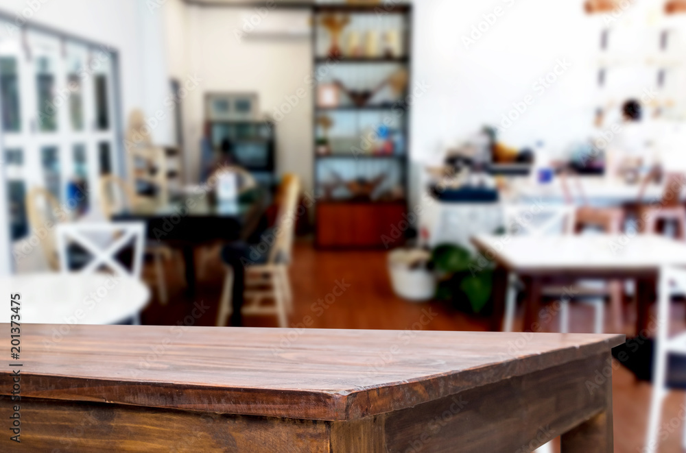 Selected focus empty brown wooden table and Coffee shop or restaurant blur background with bokeh image. for your photomontage or product display. Selected focus empty brown wooden table and Coffee shop or restaurant blur background with bokeh image. for your photomontage or product display.