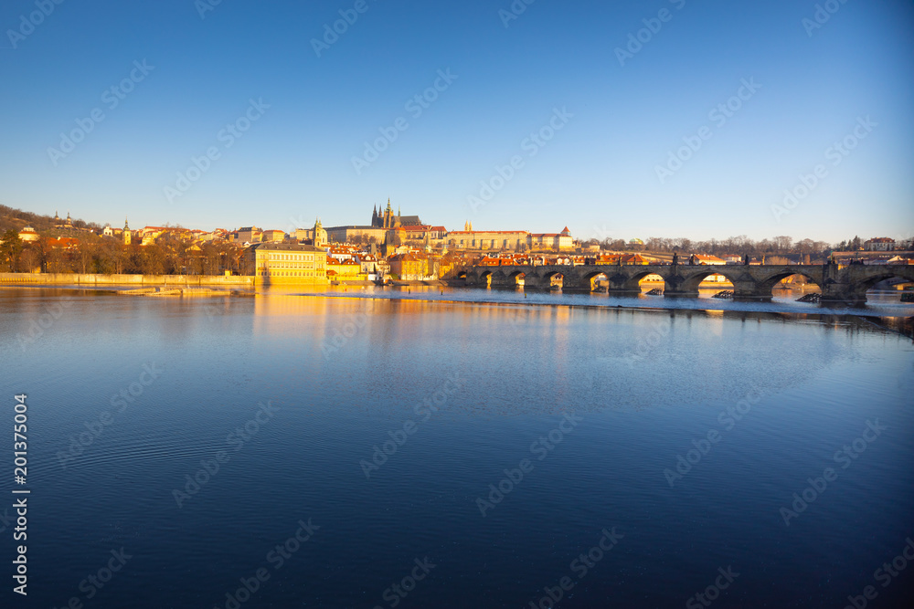 Charles Bridge and Prague castle over river Vltava at sunrise light in early morning