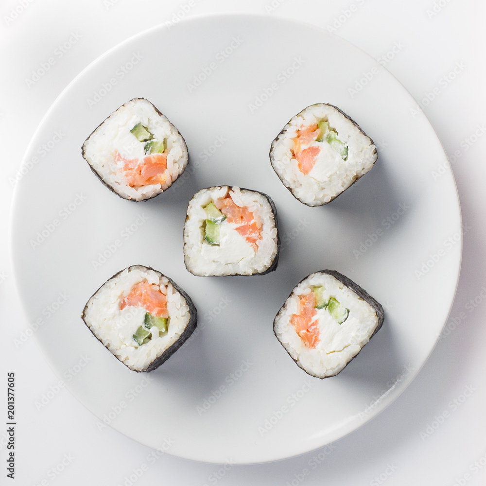 Roll of sushi on a plate, Sushi roll on a tablet on the table restaurant / eating sushi roll using chopsticks, white background, Sushi roll and hand with chopsticks. Japanese food. Roll of sushi on a plate, Sushi roll on a tablet on the table restaurant / eating sushi roll using chopsticks, white background, Sushi roll and hand with chopsticks. Japanese food.