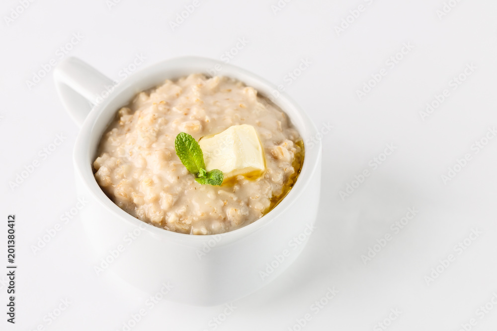 breakfast: oatmeal porridge with butter in white bowl on white background. Isolated breakfast: oatmeal porridge with butter in white bowl on white background. Isolated