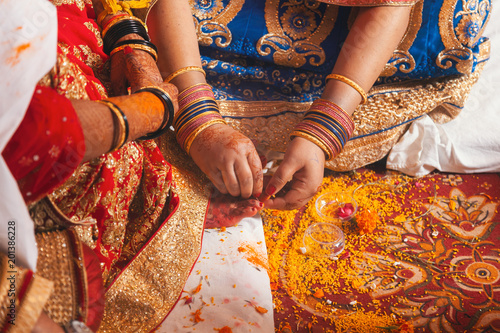Indian bride in a Feet Coloring Ceremony during a Hindu wedding ritual.