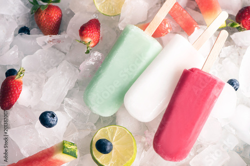 Homemade  popsicles on ice and fruits, top view