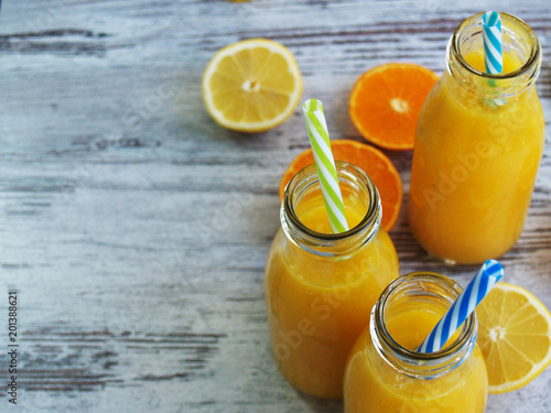 Jaune, saint et frais jus de fruits juteux (oranges et citrons), servi en verre  photo