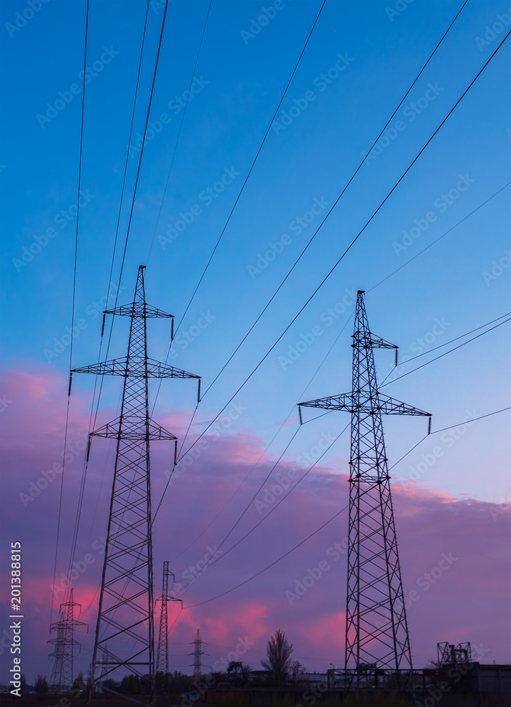 Silhouette image of the high voltage electricity pole with sky on sunset time.