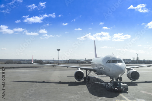 airplane is dragged by car airport and docking in international airport with sunny blue sky background