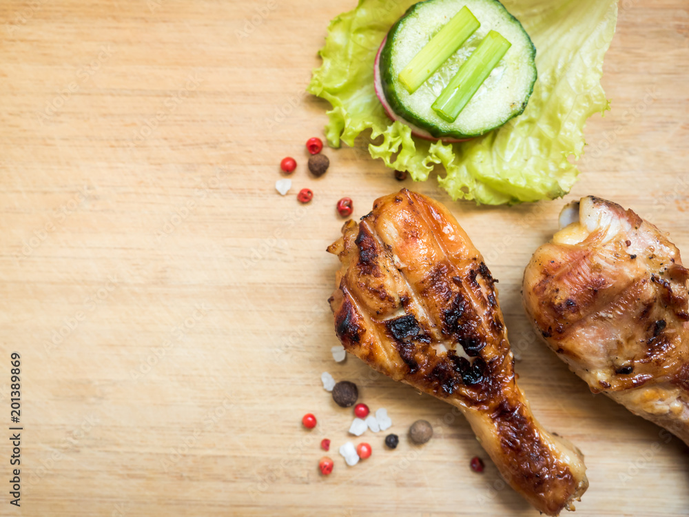 Grilled chicken drumsticks on a wooden Board with fresh vegetables Selective focus Grilled chicken drumsticks on a wooden Board with fresh vegetables Selective focus