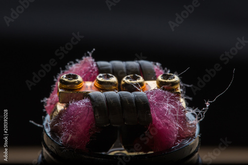 Vape close-up with wet cotton wool on black background photo