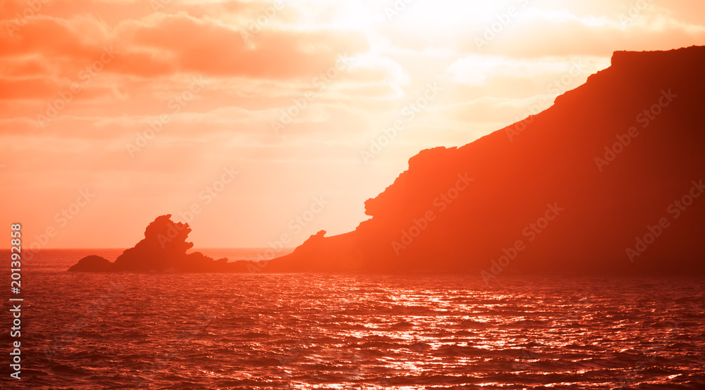 Landscape with coastal rocks in red sunlight