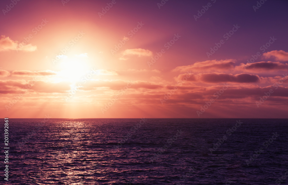 Seascape with sun in dramatic cloudy sky