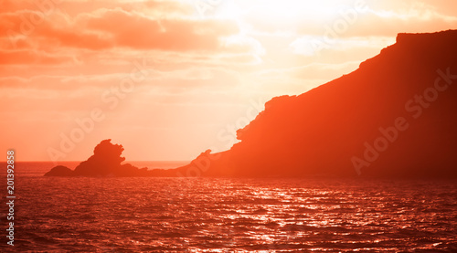 Landscape with coastal rocks in red sunlight