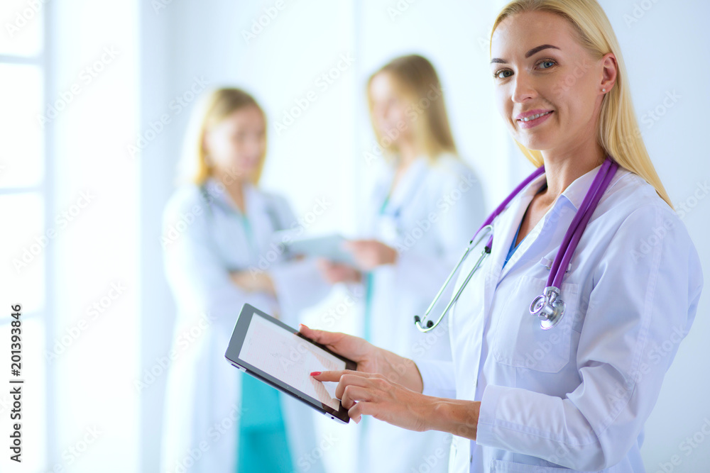 portrait of a young female doctor, with aipads in hand, in a medical office portrait of a young female doctor, with aipads in hand, in a medical office