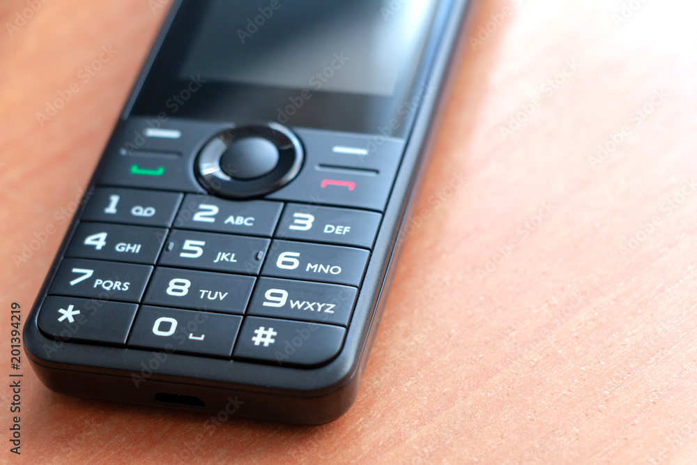 Obsolete new push-button phone on the table, impossible to crack Obsolete new push-button phone on the table, impossible to crack