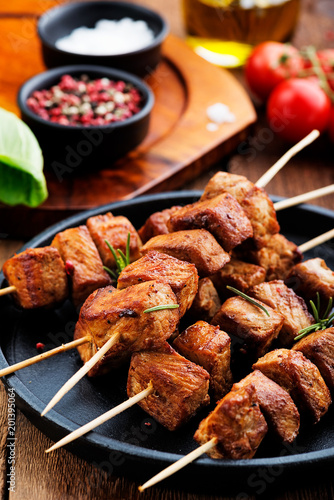 Grilled meat skewers, shish kebab on dark wooden background, top view