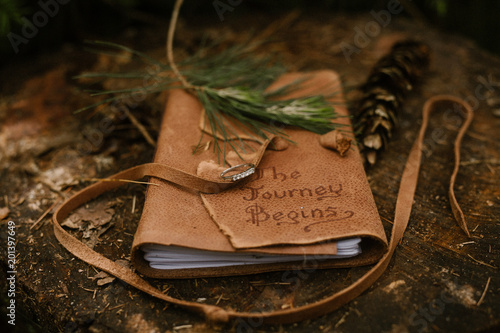 leather journal outside on a log photo