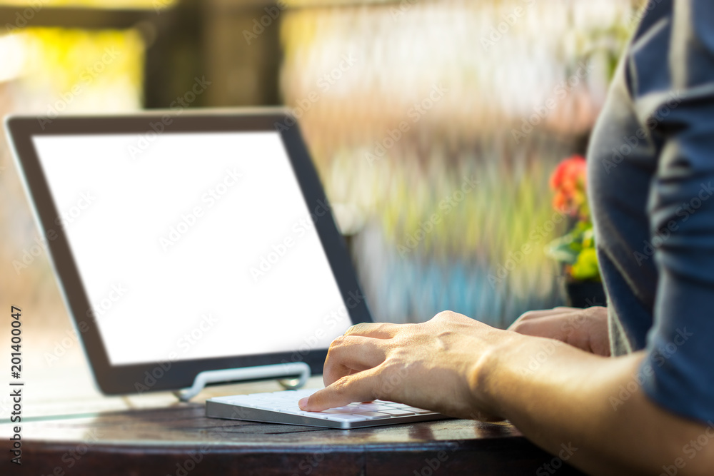 Woman is using a tablet and typing keyboard in the garden. Woman is using a tablet and typing keyboard in the garden.