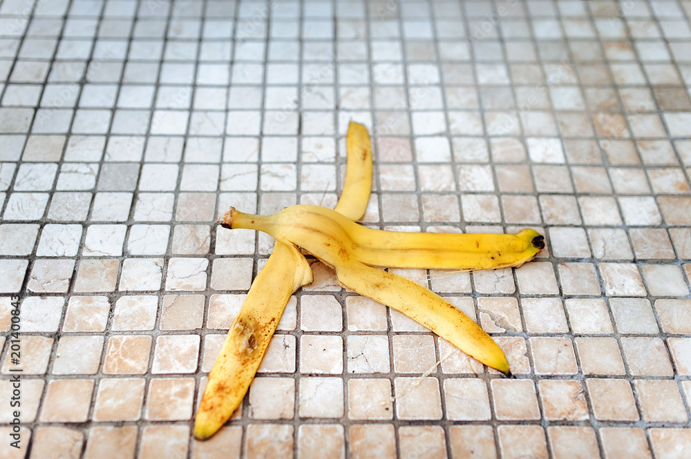 Peel of banana on a floor. Slippery floor. Risk, failure, danger concept. Stock Photo Adobe Stock