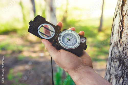 Hand Holding Military Compass Into The Woods In Sunny Day