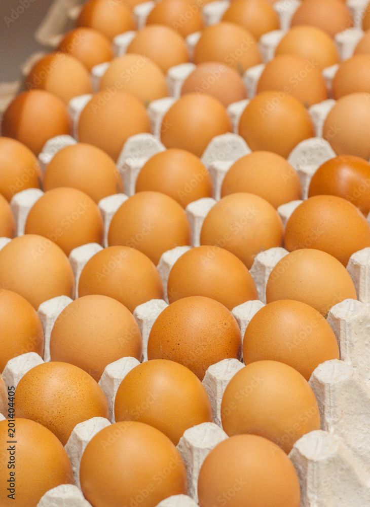 Many brown eggs in boxes in store close up