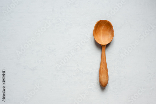 A wooden spoon handmade lies on a gray background.