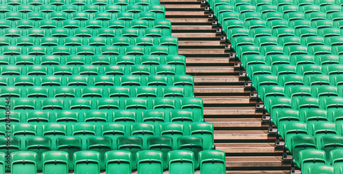 Green empty stadium folding seats and wooden stairs photo