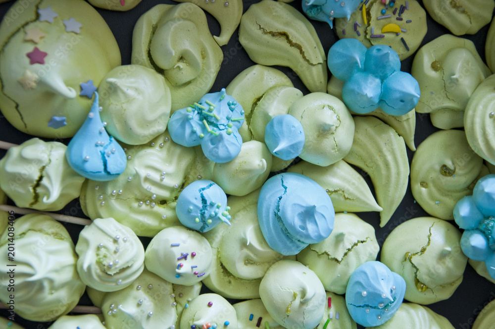 meringue top view background. sea shell dessert. trendy french cookies flat lay. green and blue color candy. whipped egg white sweets
