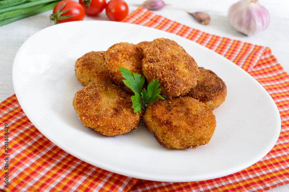 Cutlets. Juicy meat cutlets on a white plate on a wooden background. Cutlets. Juicy meat cutlets on a white plate on a wooden background.