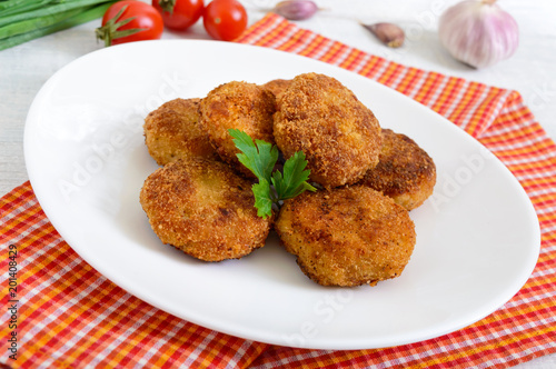 Cutlets. Juicy meat cutlets on a white plate on a wooden background.