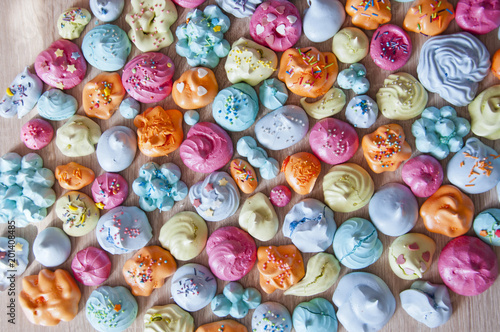 Birthday party celebration with sweet dessert, flat lay. Meringues with colorful sprinkles. Macaron meringue with colorful topping. Punchy pastels with meringue flat lay. Sprinkles top on candy