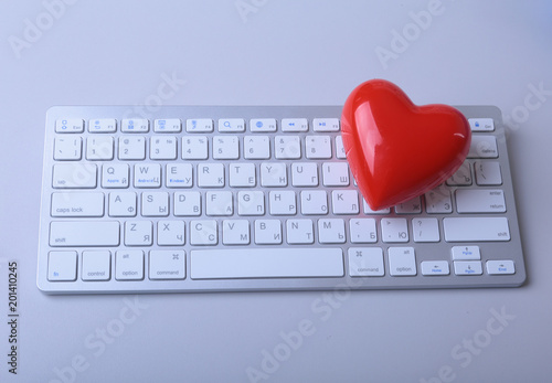 Small red heart on keyboard. Internet dating concept photo