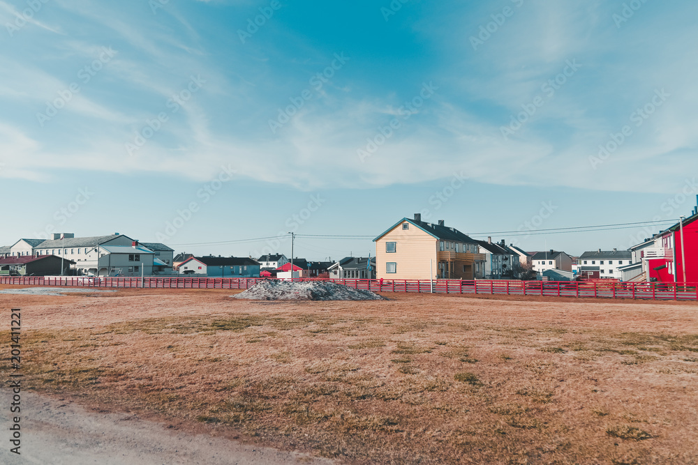 Fototapeta premium Norway Vardo, houses in a neighborhood on a summer day with some snow still left