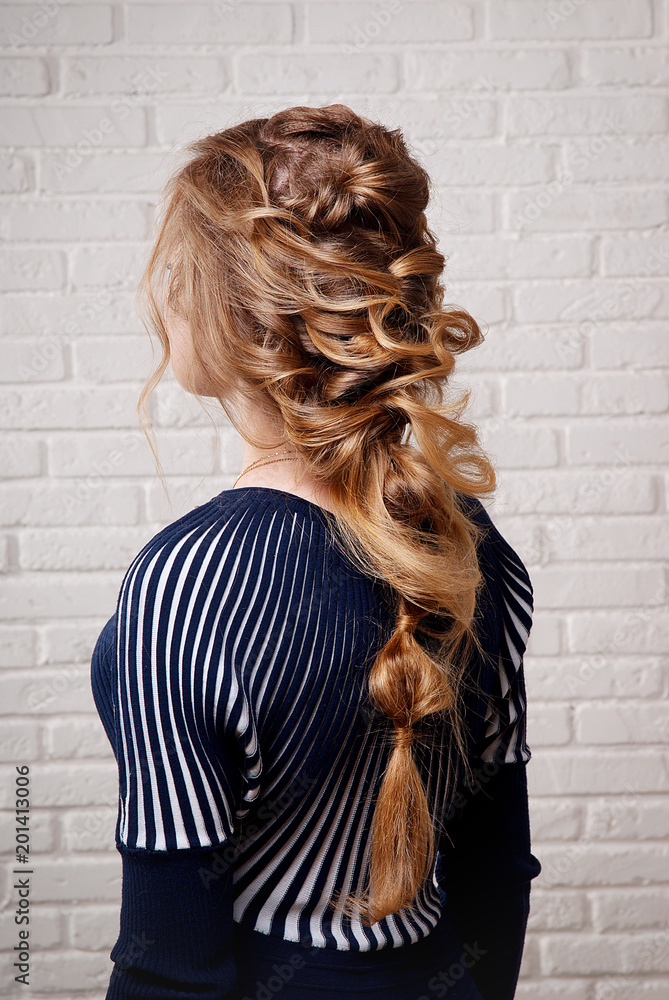 The Greek braid hairstyle on your head blonde side view in front of a white  brick wall  women's hairstyle. Stock Photo | Adobe  Stock