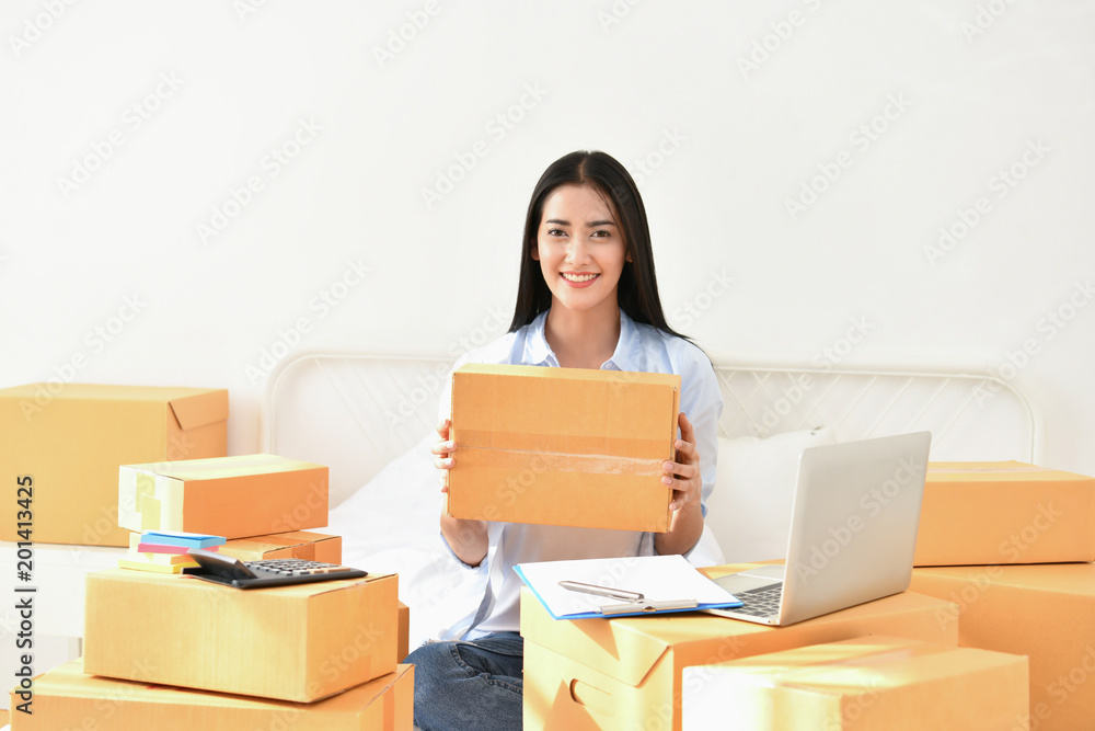 Sme business concept. Young people are packing their packages.Delivery business Small and Medium Enterprise (SMEs). Young woman is working in the house.Young Owner Start up for Business Online. Sme business concept. Young people are packing their packages.Delivery business Small and Medium Enterprise (SMEs). Young woman is working in the house.Young Owner Start up for Business Online.