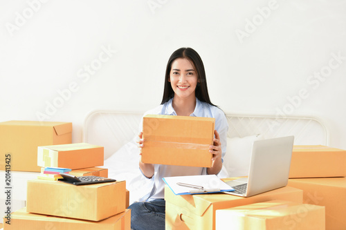 Sme business concept. Young people are packing their packages.Delivery business Small and Medium Enterprise (SMEs). Young woman is working in the house.Young Owner Start up for Business Online.
