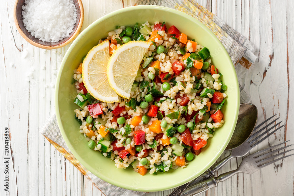 Fresh salad with bulgur and vegetables on white wooden table Fresh salad with bulgur and vegetables on white wooden table
