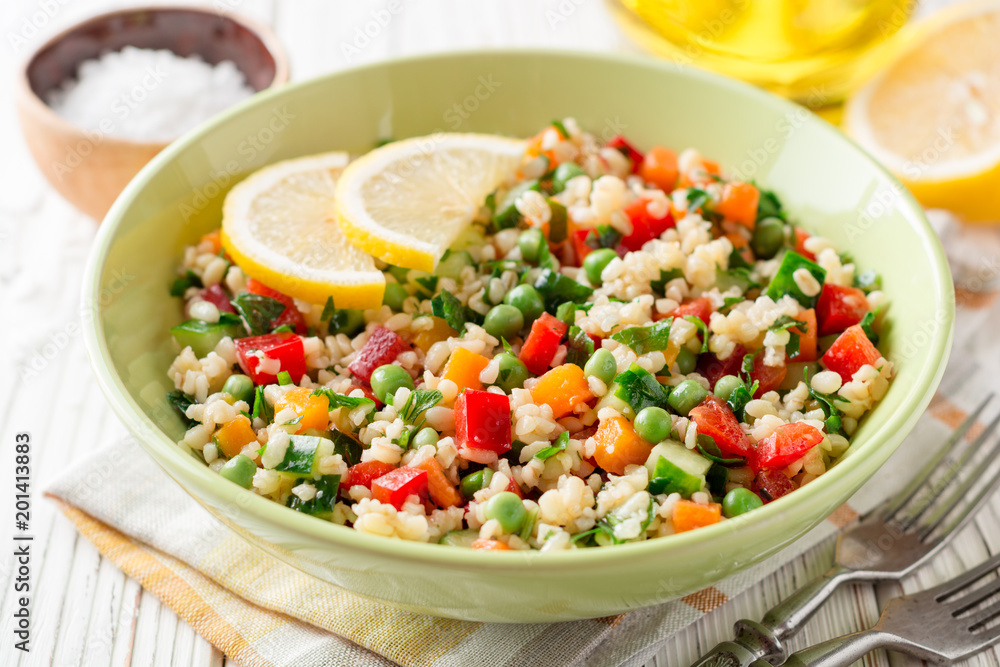 Fresh salad with bulgur and vegetables on white wooden table Fresh salad with bulgur and vegetables on white wooden table