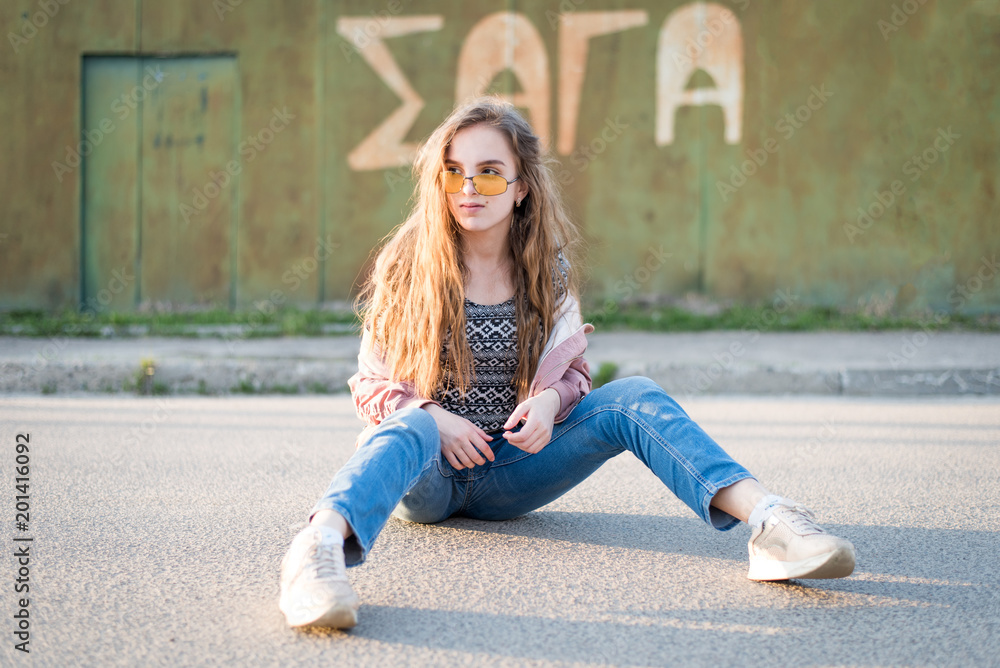 Young beautiful woman on the street. Emotions, people, beauty and lifestyle concept. Street photo of young woman wearing stylish casual clothes. Female fashion concept. Cute teenage girl.