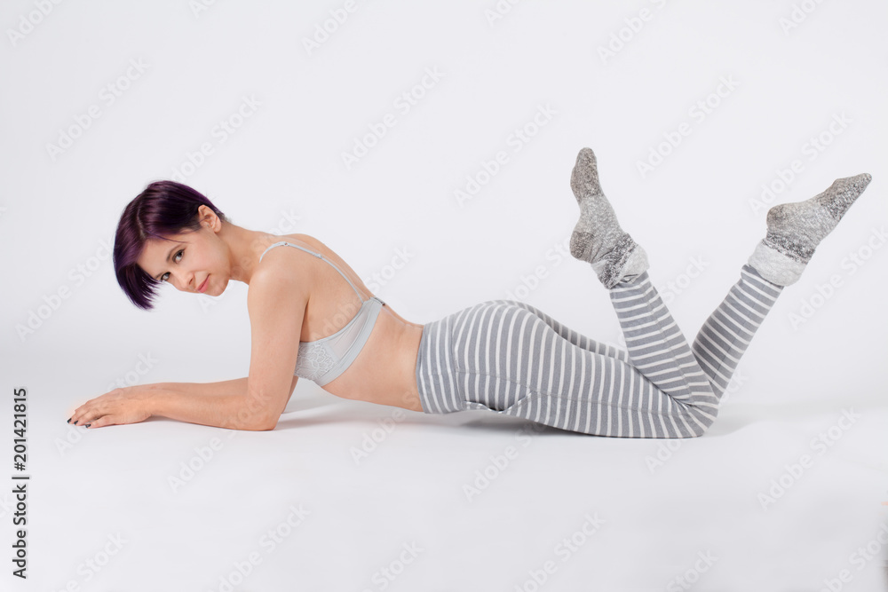 Cute Woman in Pajama Pants, Socks, and Bra Lying Prone With Feet in the Air  Stock Photo