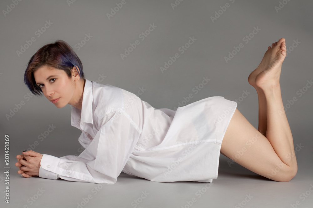 Woman in Man's Shirt and Panties Lying on Stomach Stock Photo