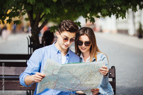 summer holidays, dating and tourism concept - smiling couple tourists in sunglasses with map in the new city