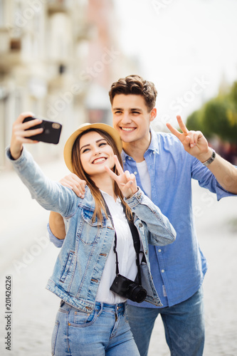 Couple of tourists photographing a selfie in a city street. Travel concept photo