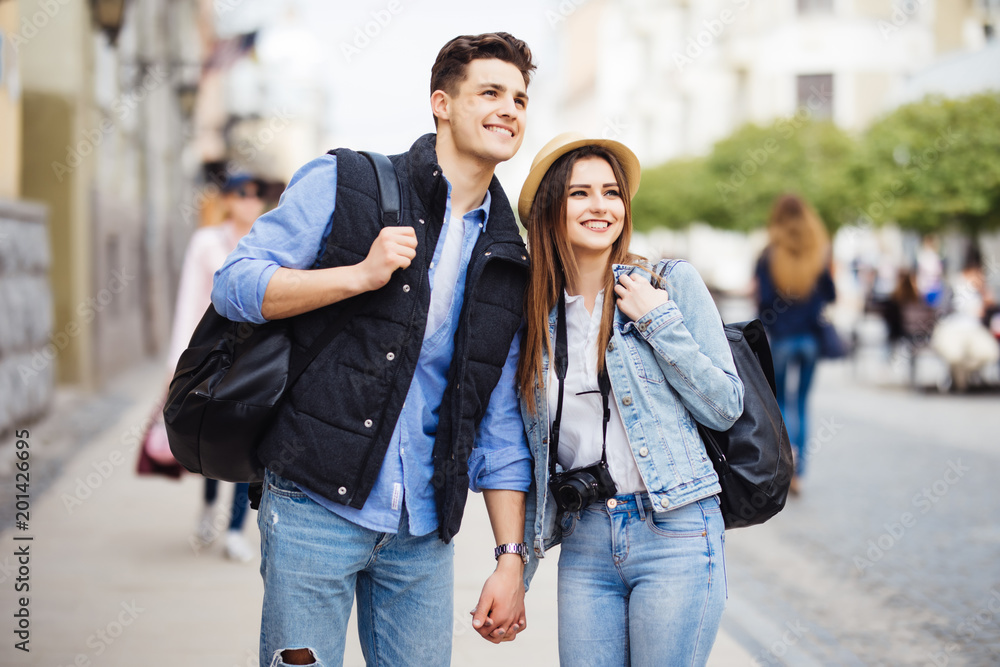 Fototapeta premium Young freelancing photographers enjoying traveling and backpacking. Young couple with backpack travel new destination