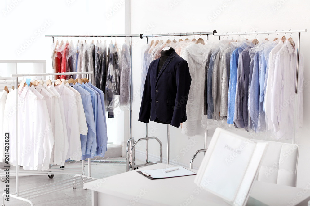 Dry-cleaner's interior with clothes on racks