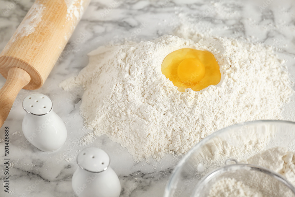 Pile of flour with egg on table in kitchen Pile of flour with egg on table in kitchen